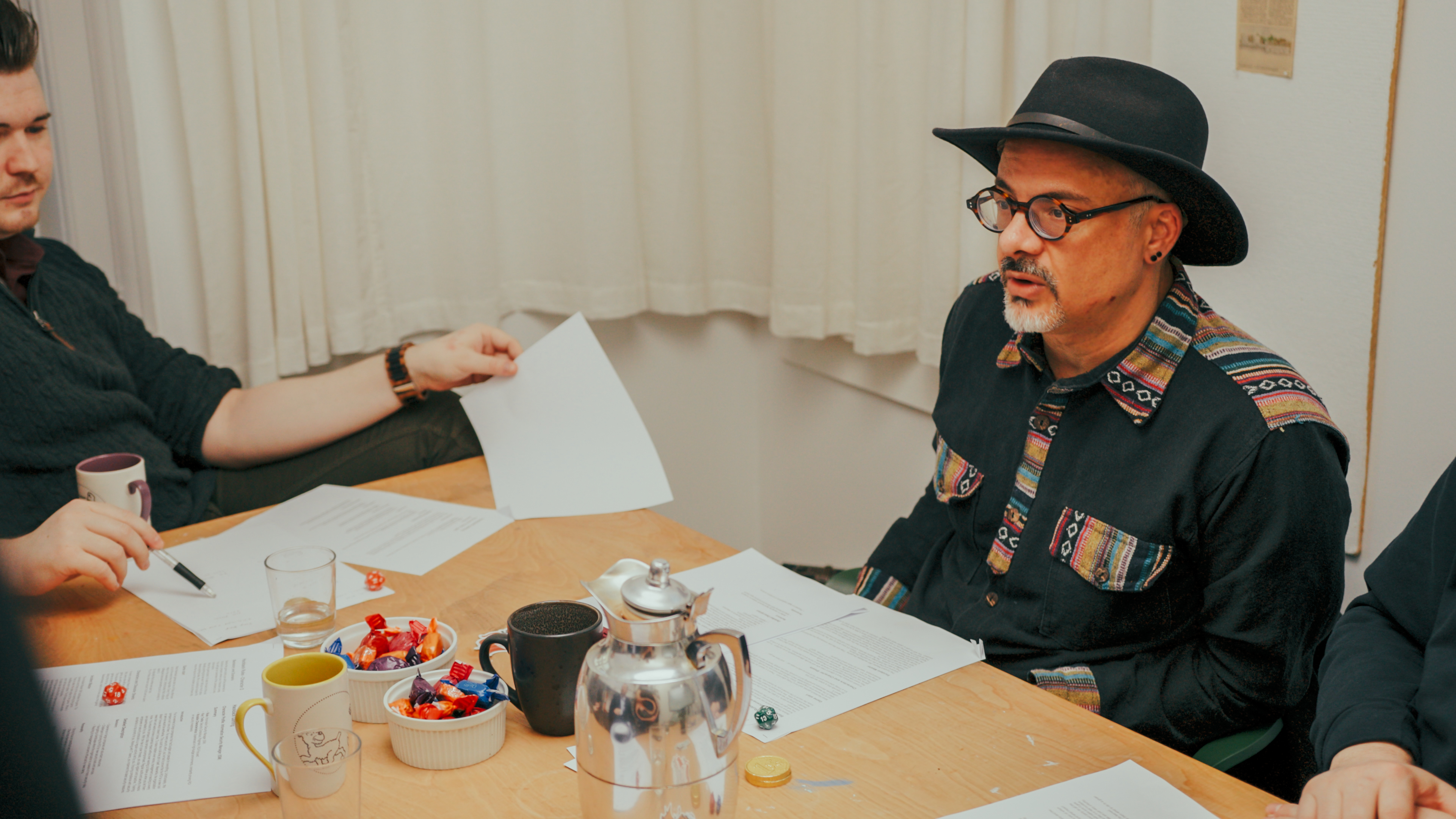 Workshop participants working through a risk scenario with printed briefing sheets and dice around a table